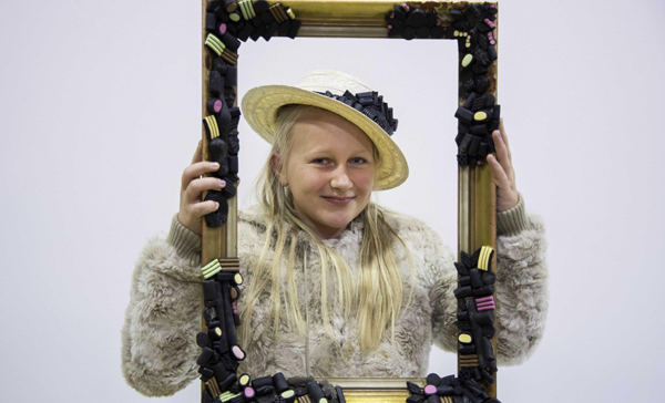 HELSINKI, Oct. 28, 2019 (Xinhua) -- A girl poses with a frame decorated with licorice at the selfie stand at the licorice festival in Helsinki, Finland, on Oct. 27, 2019. The licorice festival of this year featured new licorice flavor tasting, licorice cake decoration, licorice knowledge lecture, etc. Photo by Matti Matikainen/Xinhua/UNI PHOTO-1F