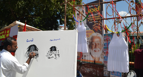 THIRUVANANTHAPURAM, NOV 1 (UNI)- An artist staging protest over the acquittal of three accused in mysterious deaths of two Dalit girls at Walayar, by drawing on a canvas in front of Kerala Secretariat in Thiruvananthapuram on Friday. UNI PHOTO-51U