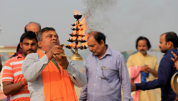 PRAYAGRAJ, NOV 25 (UNI)- Devotees offering Ganga aarti after taking holy dip on foggy Monday morning in Prayagraj. UNI PHOTO-6u