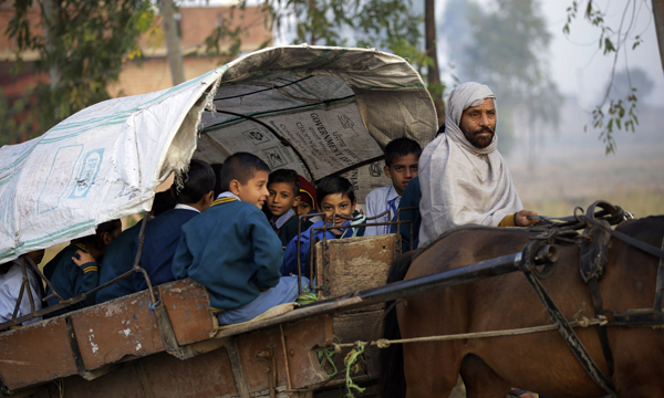 JAMMU, NOV 19 (UNI)- School children riding a horse drawn cart on way to their school during a chilling winter morning on the outskirts of Jammu city on Tueday. UNI PHOTO-6U