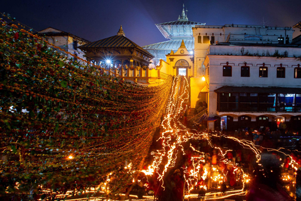 KATHMANDU, Nov. 25 (Xinhua) -- Devotees holding oil lamps perform a ritual on the bank of Bagmati River near the Pashupatinath Temple during the Bala Chaturdashi festival in Kathmandu, Nepal, Nov. 25, 2019. Devotees celebrated the festival by lighting oil lamps a whole night and scattering seven types of grains in early morning at the temple. Xinhua/ UNI PHOTO-3F