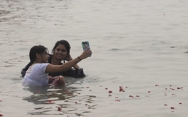 PRAYAGRAJ, NOV 4 (UNI)- Girls taking selfie while taking a dip at Sangam, during a smoggy morning in Prayagraj on Monday. UNI PHOTO-8U