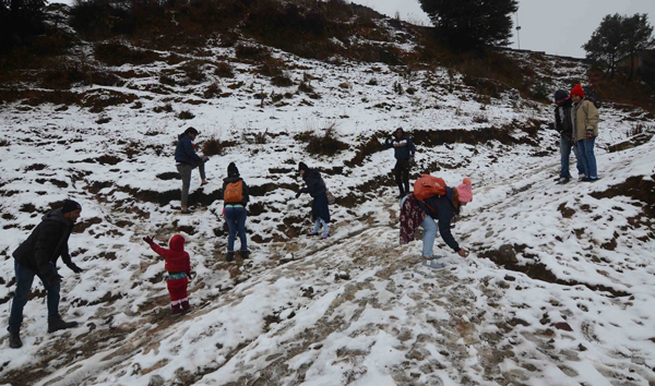 SHIMLA, NOV 28 (UNI):-Tourists enjoying season first snowfall at Kuffri, in Shimla on Thursday.UNI PHOTO-55U