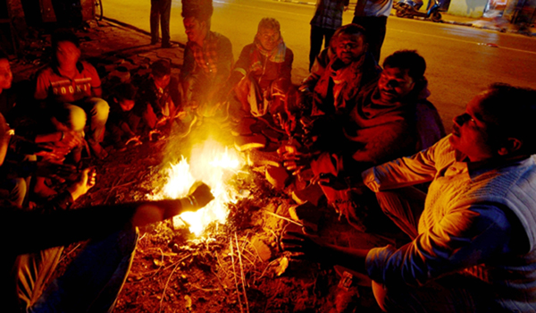 Kolkata: People warm themselves around the fire on a chilly winter evening in Kolkata on Dec 22, 2019. (Photo: Kuntal Chakrabarty/IANS)