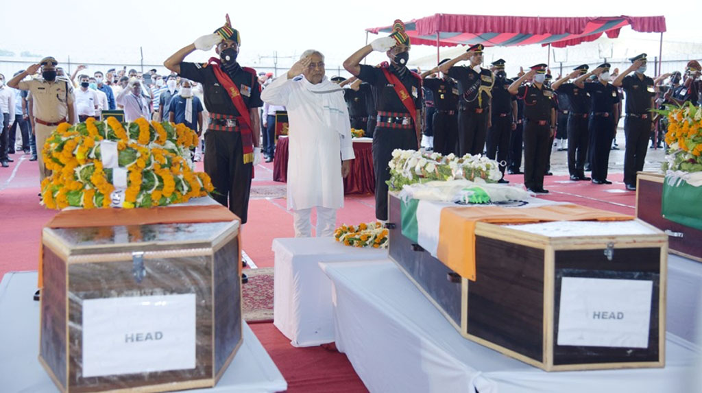 Patna: Bihar Chief Minister Nitish Kumar pays his respect to the mortal remains of martyrs who among 20 Indian soldiers killed in a clash with Chinese forces in Galwan Valley along the Line of Actual Control (LAC) in eastern Ladakh region on Monday; during wreath laying ceremony at Jay Prakash Narayan International Airport in Patna on June 18, 2020. (Photo: IANS)