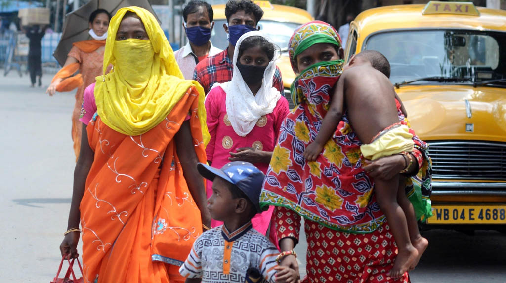 Kolkata: Migrant returnees walk past a Kolkata street after arriving in the city during the fifth phase of the nationwide lockdown imposed to mitigate the spread of coronavirus, on June 5, 2020. (Photo: Kuntal Chakrabarty/IANS)