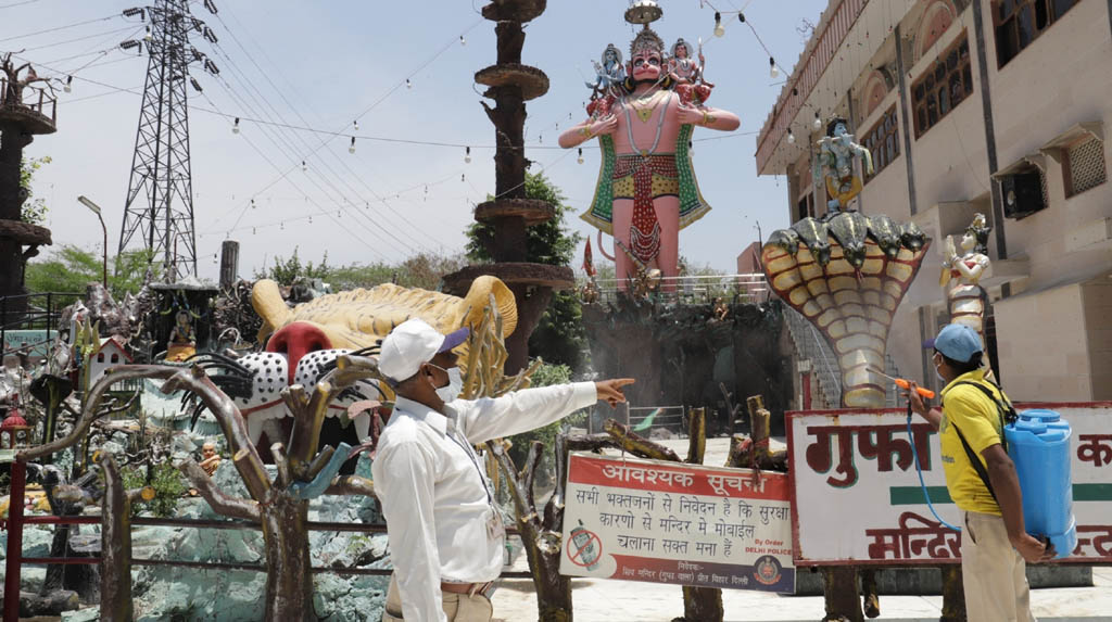 Amritsar: A municipal worker sprays disinfectant at Gufa Wala Mandir in Delhi's Preet Vihar as it gears up to reopen for devotees from tomorrow as part of Unlock 1.0 or phased relaxation during the fifth phase of the nationwide lockdown imposed to mitigate the spread of coronavirus, on June 7, 2020. (Photo: IANS)