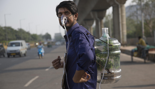 NOIDA, DEC 2 (Xinhua) -- A young man named Pankaj Kumar wearing an oxygen mask and carrying a 20-liter plastic water bottle strapped to his back to raise awareness of saving environment in highly polluted National capital Region. Xinhua/ UNI PHOTO-1U
