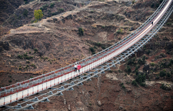 (191215) -- WEINING, Dec. 15, 2019 (Xinhua) -- People walk on a bridge spanning the Niulan River in southwest China on Dec. 11, 2019. Cableway once became the main means of transportation along the Niulan River for villagers of Weining in Guizhou and Huize County in Yunnan Province. Since 2013, the local government has been dedicated in replacing the cableway with bridge along the Niulan River. (Xinhua/Yang Wenbin)