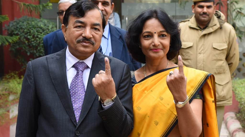 New Delhi: Election Commissioner Sushil Chandra and his wife show their inked fingers after casting their votes for Delhi Assembly elections 2020 at Wonderland Kids School in Delhi's New Moti Bagh on Feb 8, 2020. (Photo: IANS/PIB)