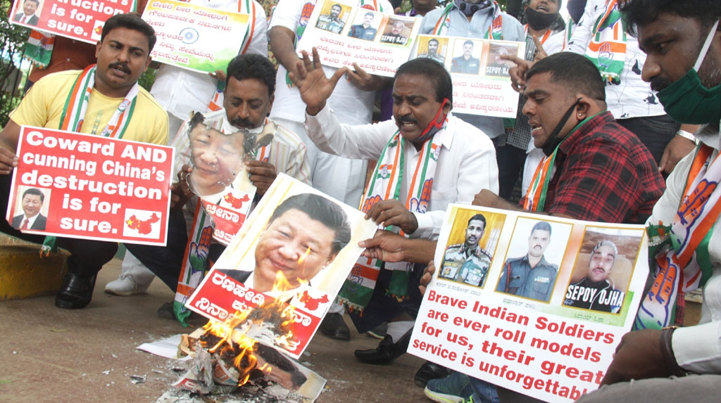 Bengaluru: Youth Congress activists burn the posters of Chinese President Xi Jinping during protest against the brutal attack on Indian Army personnel at Galwan valley at the Line of Actual Control that has killed 20 Indian soldiers during the Indo-Chinese face off in Ladakh; in Bengaluru on June 17, 2020. (Photo: IANS)